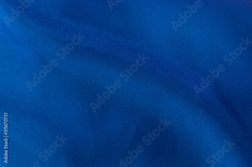 Luxury deep blue fabric background.Smooth pattern.Silk velvet material texture.Using for backdrop or wallpaper.Dark tone color.Soft focus.