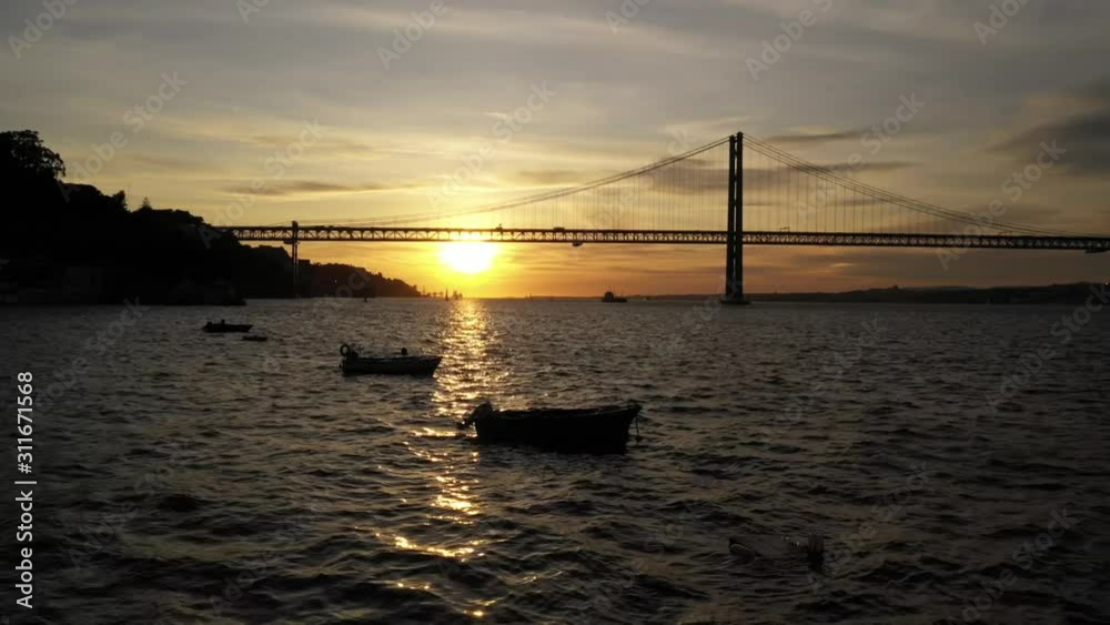 aerial shot over man filming silhouette with 25th april brigde background aerial shot over man filming silhouette with 25th april brigde background
