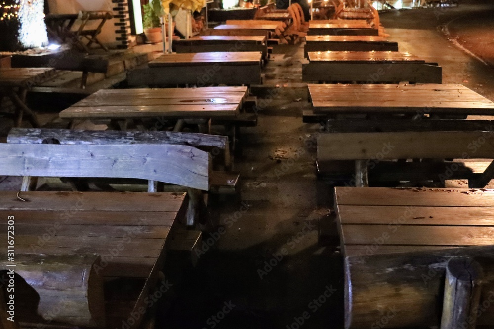 wooden tables and chairs in a garden after rain