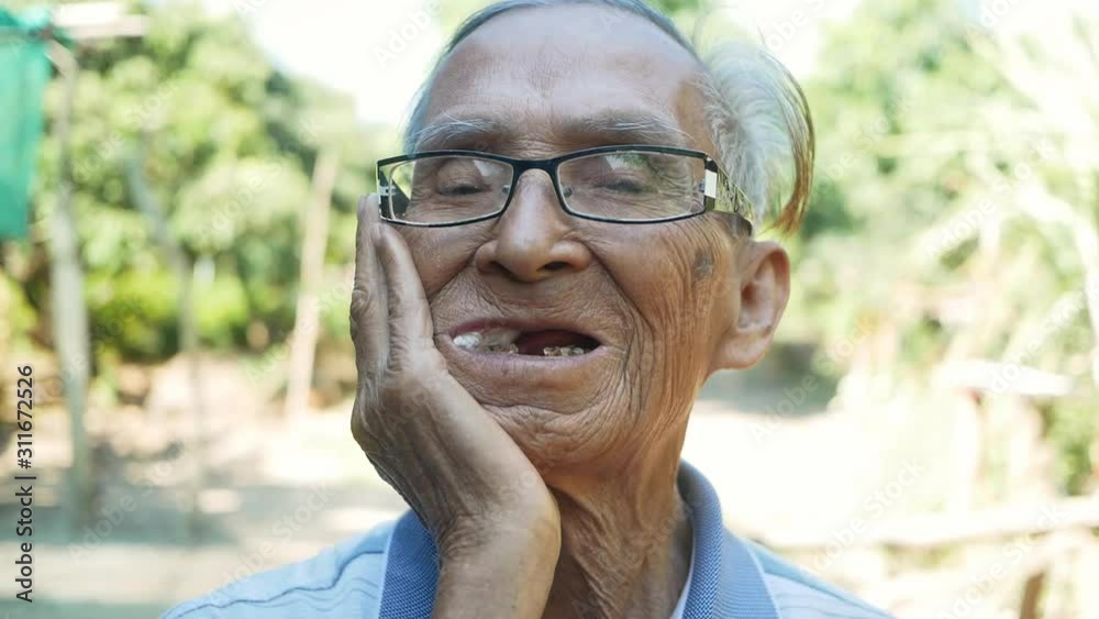 Elderly man biting on cotton gauze after tooth extraction, Tooth decay