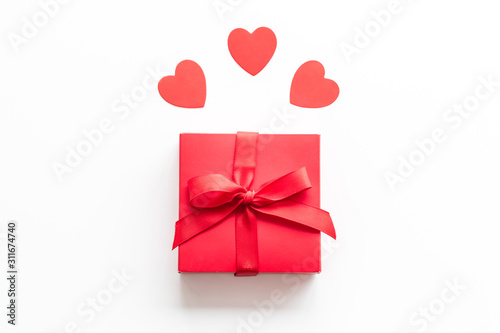 Gift to a sweetheart on Valentine s Day. Red present box near hearts on white background top-down copy space