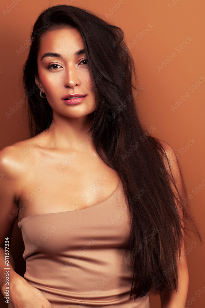 young pretty asian woman cheerful smiling posing on warm brown background, lifestyle people concept young pretty asian woman cheerful smiling posing on warm brown background, lifestyle people concept