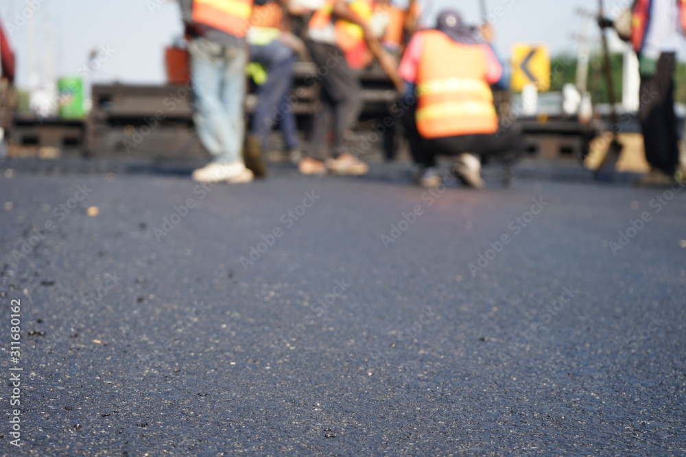 Construction workers on the asphalt road, blurred pictures Construction workers on the asphalt road, blurred pictures