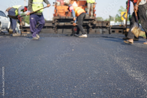Construction workers on the asphalt road, blurred pictures