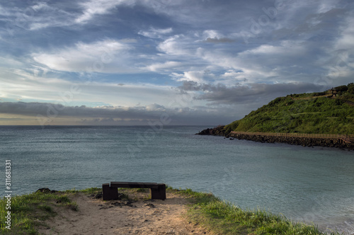 lava rock bench with Hamdeok Beach landscape photo