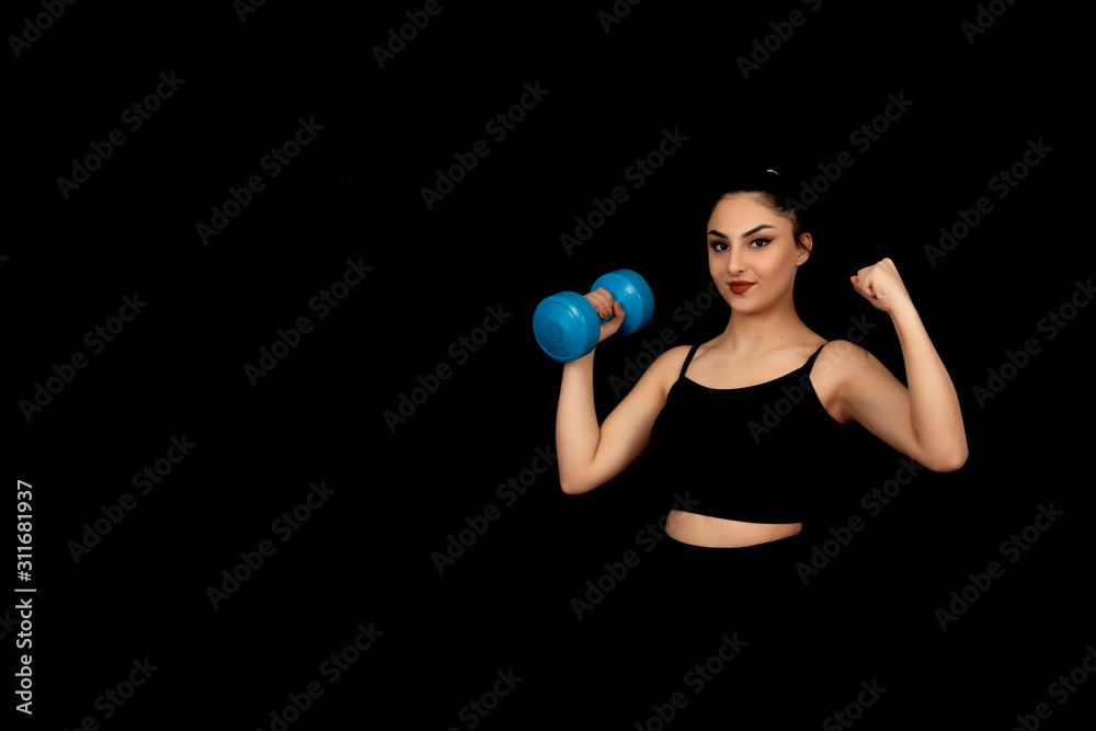 Strong looking girl doing sports on a black background Strong looking girl doing sports on a black background