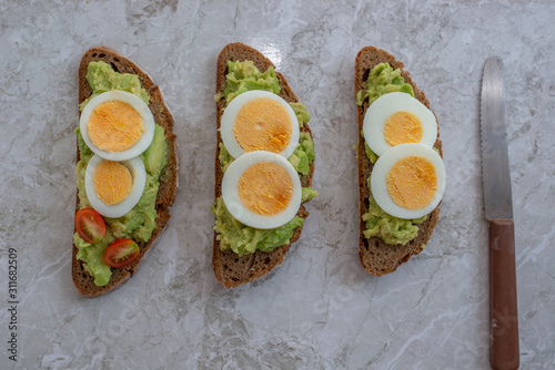 sliced avocado and egg on toasted bread 