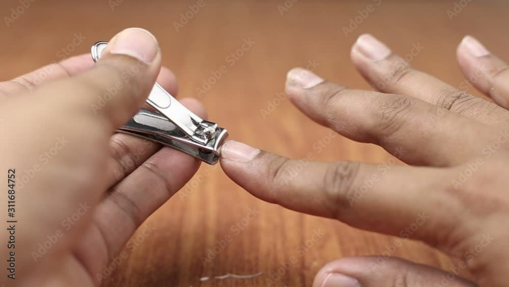 Close-up fingers. Cutting nail with nail clipper. Close-up fingers. Cutting nail with nail clipper.