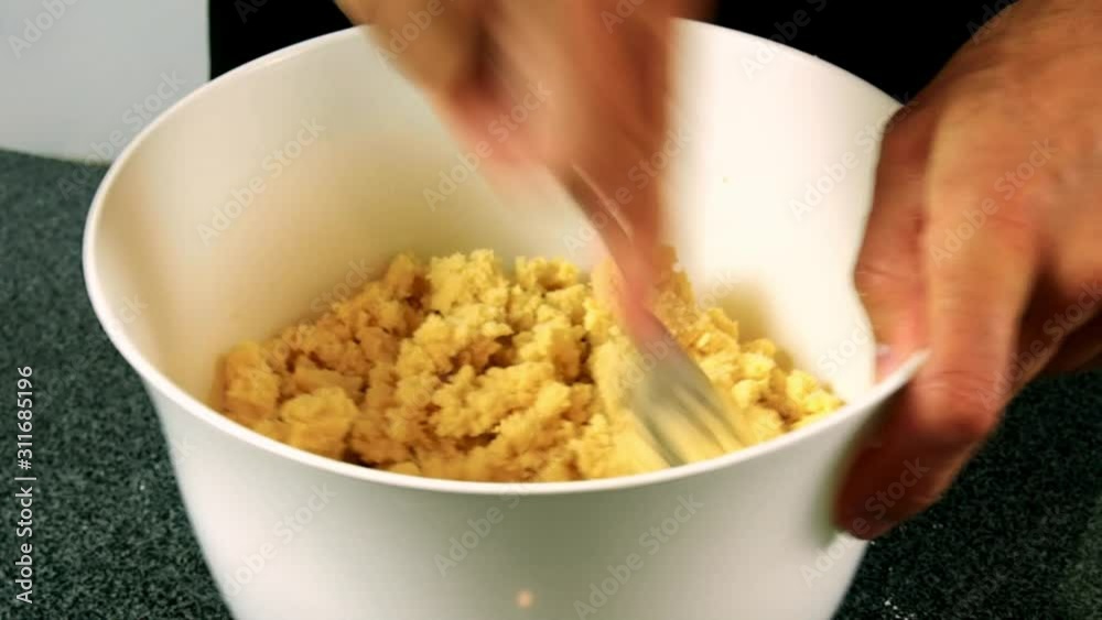 Stirring dough in water with fork. Making shortcrust pastry dough. Stirring dough in water with fork. Making shortcrust pastry dough.