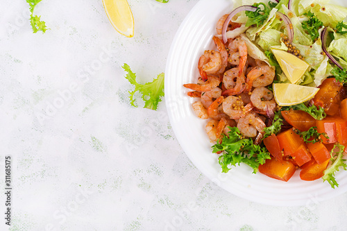 Fruit salad with fried prawns / shrimps, persimmon, red onion and lettuce in white bowls. Appetizers, snack, brunch. Healthy food. Top view, overhead, copy space
