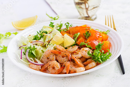 Fruit salad with fried prawns / shrimps, persimmon, red onion and lettuce in white bowls. Appetizers, snack, brunch. Healthy food.