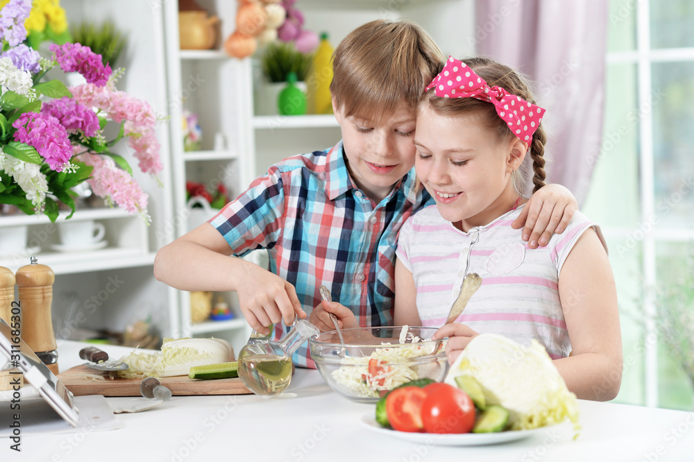 Cute brother and sister cooking together in kitchen