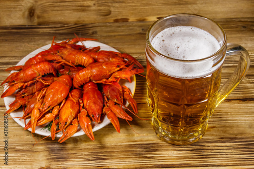Boiled crayfish and mug of beer on a wooden table