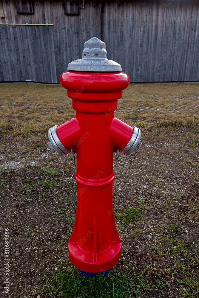 red fire hydrant next to a barn red fire hydrant next to a barn