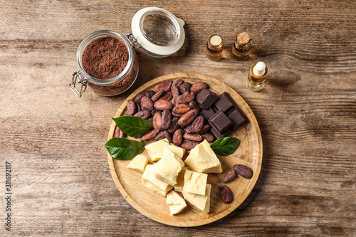 Flat lay composition with organic cocoa butter on wooden table