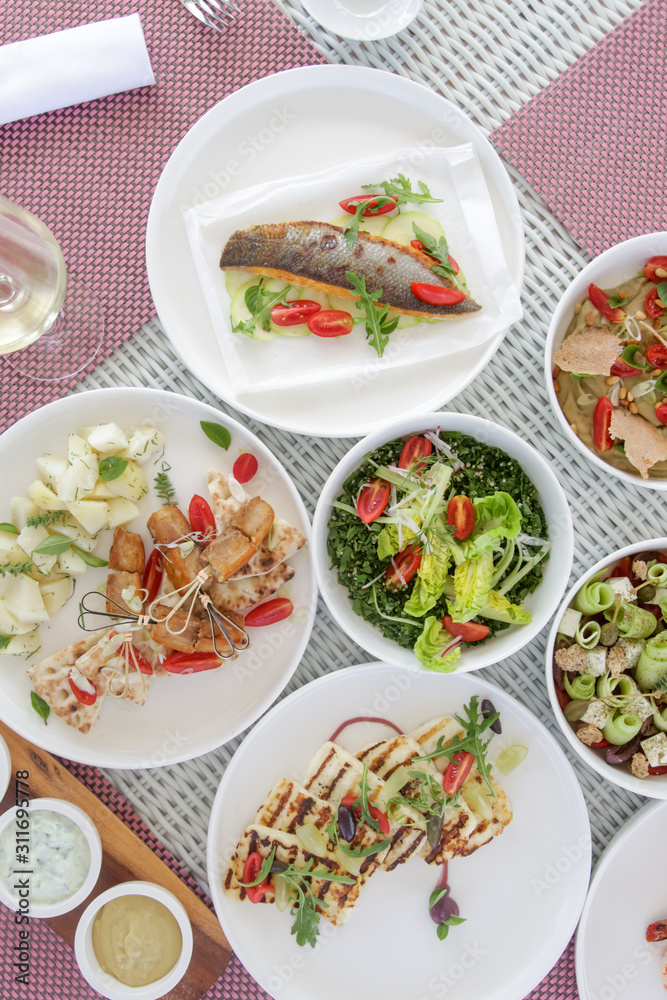 Various healthy fish and vegetables meals served on the table, healthy summer lunch