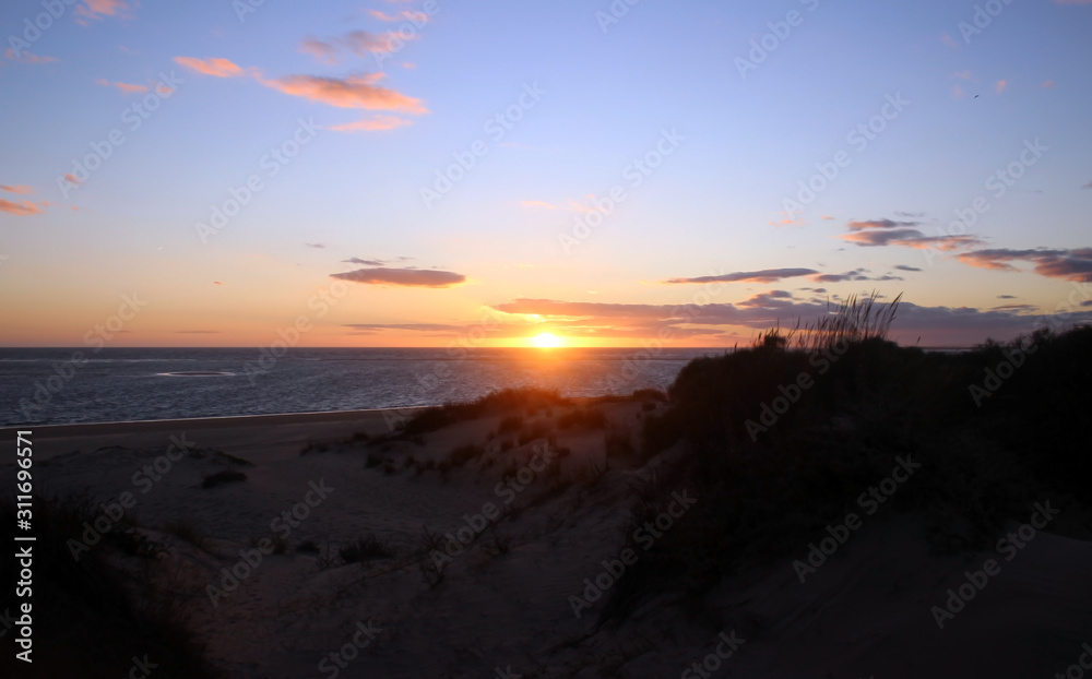 Sunrise at the beach with dunes and clear sky