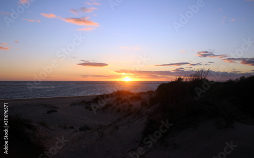 Sunrise at the beach with dunes and clear sky