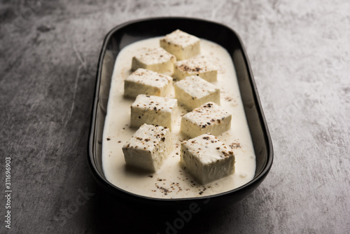 Paneer Dum Kali Mirch / Kalimirch, prepared in a white creamy gravy and black pepper powder sprinkled over it. served in a bowl. Selective focus photo