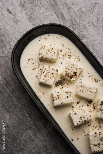 Paneer Dum Kali Mirch / Kalimirch, prepared in a white creamy gravy and black pepper powder sprinkled over it. served in a bowl. Selective focus photo