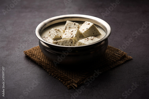 Paneer Dum Kali Mirch / Kalimirch, prepared in a white creamy gravy and black pepper powder sprinkled over it. served in a bowl. Selective focus photo