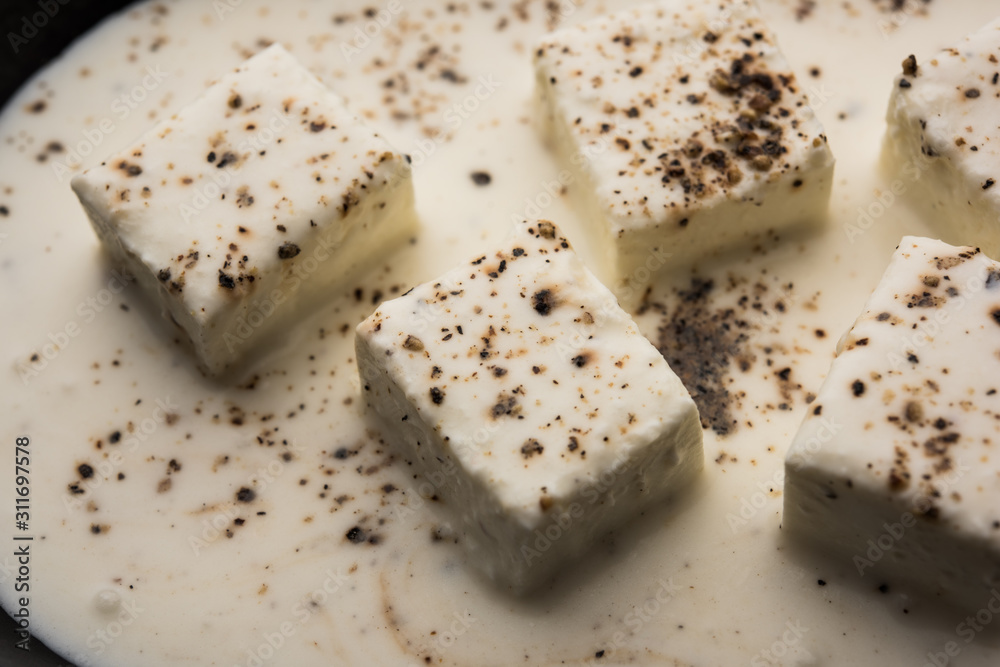 Paneer Dum Kali Mirch / Kalimirch, prepared in a white creamy gravy and black pepper powder sprinkled over it. served in a bowl. Selective focus Paneer Dum Kali Mirch / Kalimirch, prepared in a white creamy gravy and black pepper powder sprinkled over it. served in a bowl. Selective focus