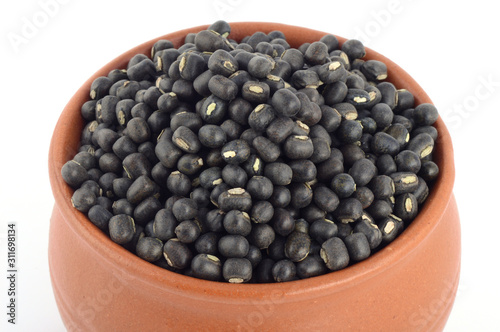 Urad dal, black gram, Vigna mungo in clay pot on white background
