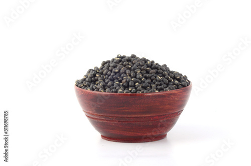 Urad dal, black gram, Vigna mungo in wooden bowl on white background