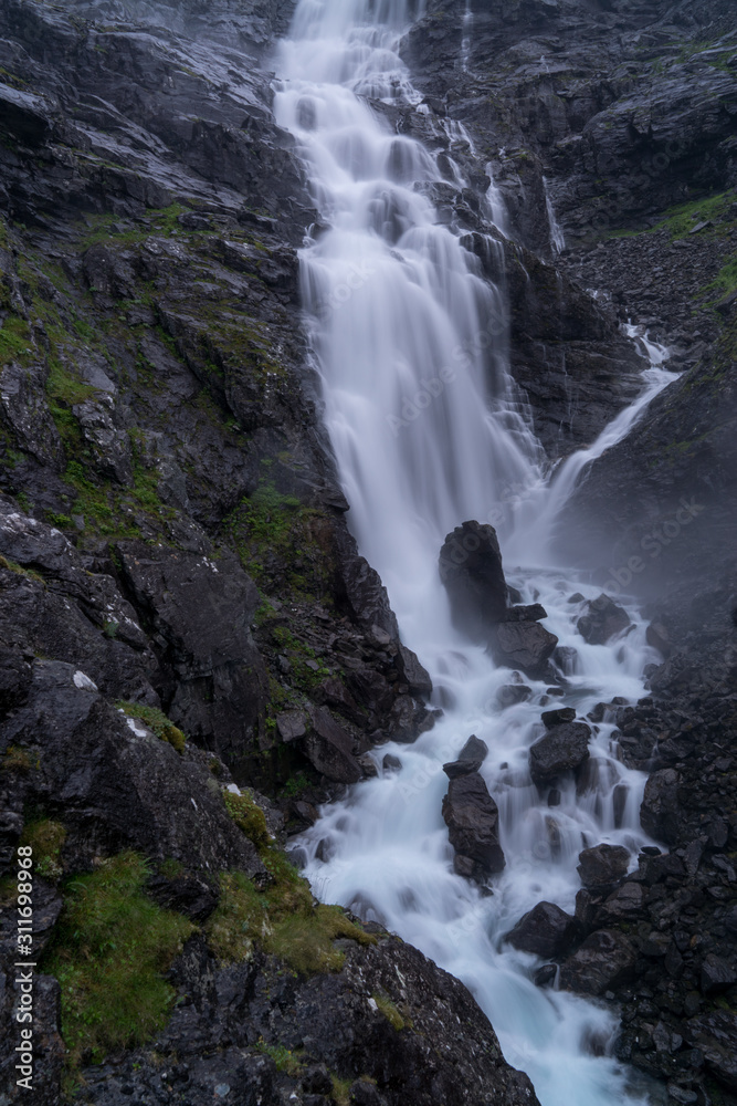 Naklejka premium Norwegian mountain road. Trollstigen. Stigfossen waterfall. Norway tourist landscape valley.