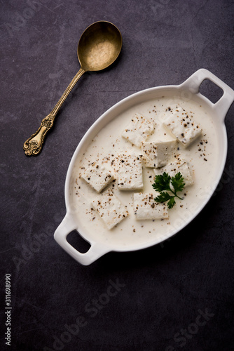 Paneer Dum Kali Mirch / Kalimirch, prepared in a white creamy gravy and black pepper powder sprinkled over it. served in a bowl. Selective focus photo