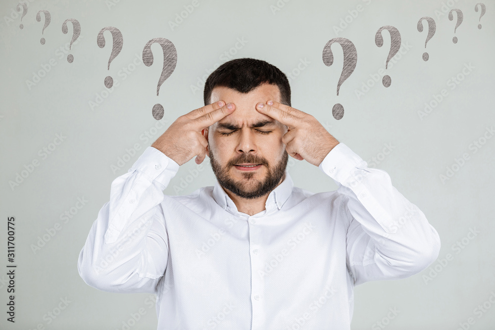 portrait of doubtful bearded man in white shirt asking questions on gray background. portrait of doubtful bearded man in white shirt asking questions on gray background.
