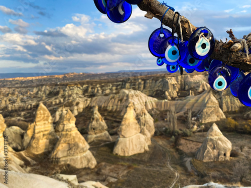 Nazar amulets hang on a tree against a background of a valley of rocks. Cappadocia, Turkey. UNESCO World Heritage. 05 december 2019