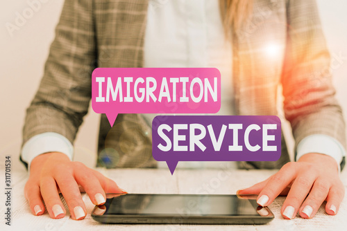 Word writing text Immigration Service. Business photo showcasing responsible for law regarding immigrants and immigration Business woman sitting with mobile phone on the table