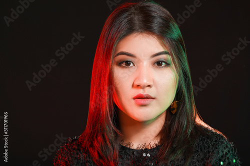 Portrait of young Asian woman on dark background