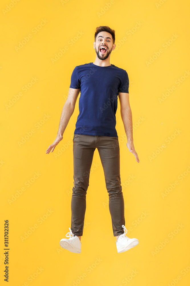 Fototapeta premium Jumping young man on color background