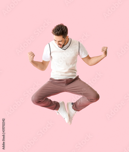 Jumping young man on color ...