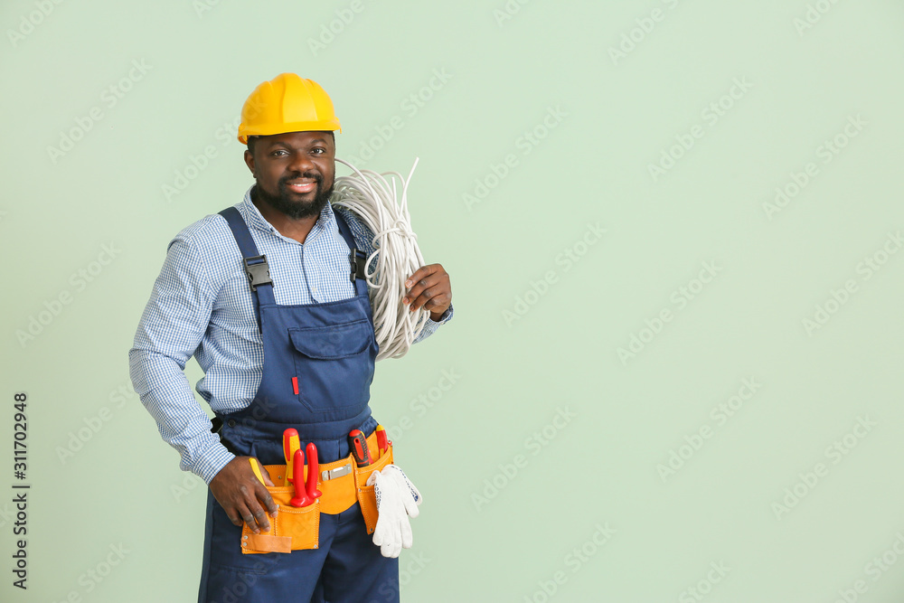 African-American electrician on color background African-American electrician on color background