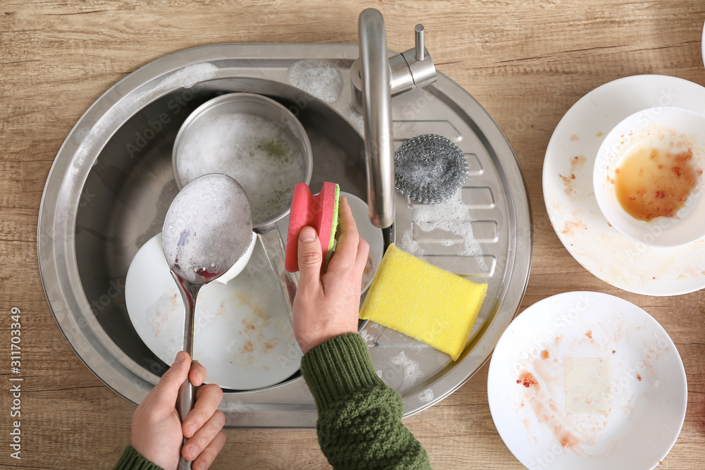 Young man washing dishes in kitchen, top view Young man washing dishes in kitchen, top view
