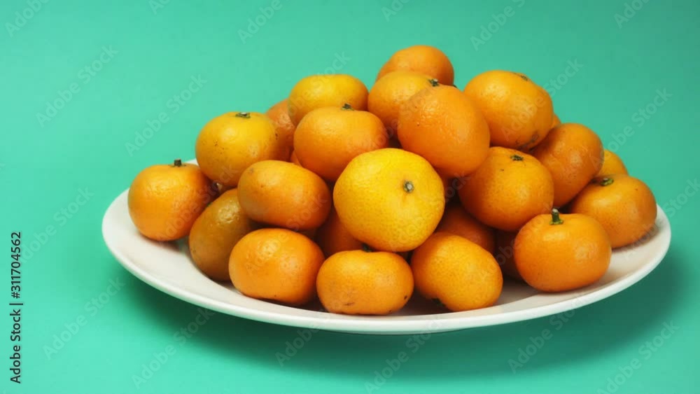large plate with tangerines on a green background large plate with tangerines on a green background