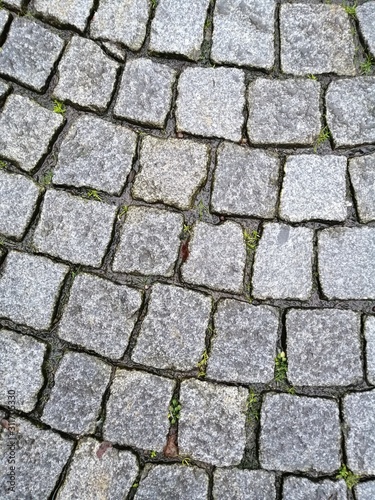Old road paved with granite stones texture background