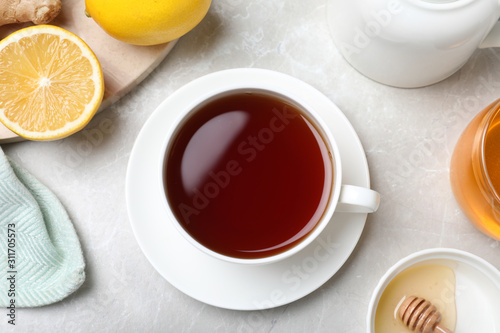 Flat lay composition of tea with honey on light grey marble table