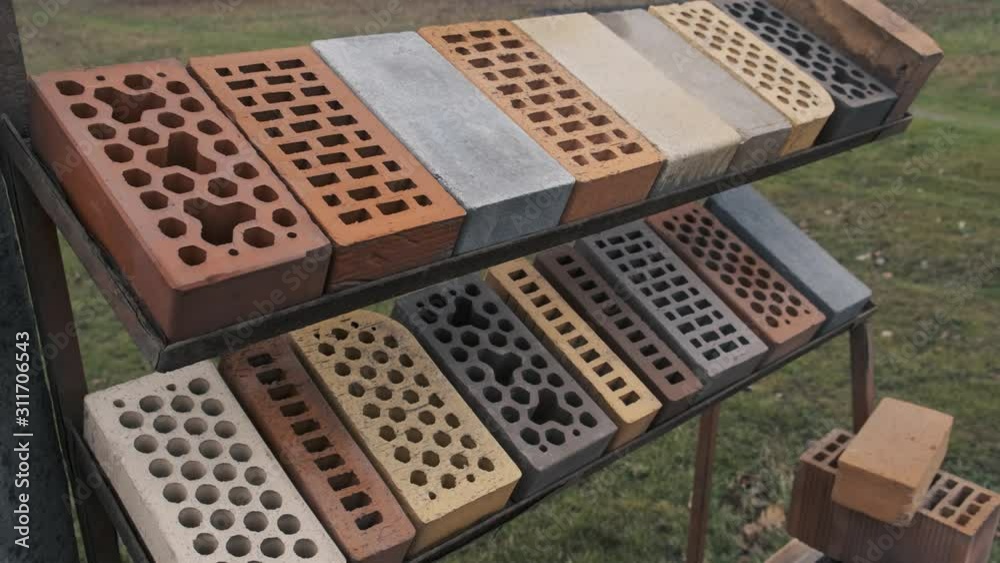 Samples of bricks differ in shape and color displayed in a row at the exhibition stand. Different types of construction bricks 4k Samples of bricks differ in shape and color displayed in a row at the exhibition stand. Different types of construction bricks 4k