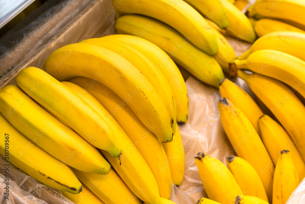 ripe delicious yellow bananas in a box, tropical fruits