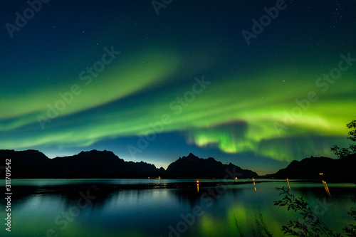 winter landscape with aurora, fjord with sky reflection and snowy mountains. Nature, Lofoten islands, Norway.