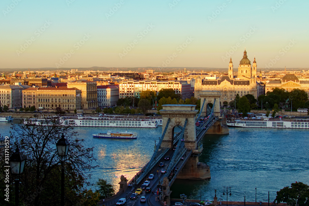 Panoramic autumn view of Budapest. Ancient Chain Bridge over Danube River. Sunset in the city. Medieval buildings along the embankment of the river. Travel and tourism concept. Budapest, Hungary