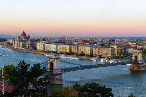 Aerial landscape view of Budapest. Picturesque view of Chain Bridge over Danube River and The Hungarian Parliament Building in the background. Scenic autumn sunset colors. Budapest, Hungary