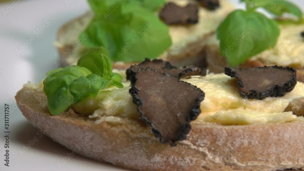 Bruschetta with slices of black truffle mushroom on the cheese sauce with basil Bruschetta with slices of black truffle mushroom on the cheese sauce with basil