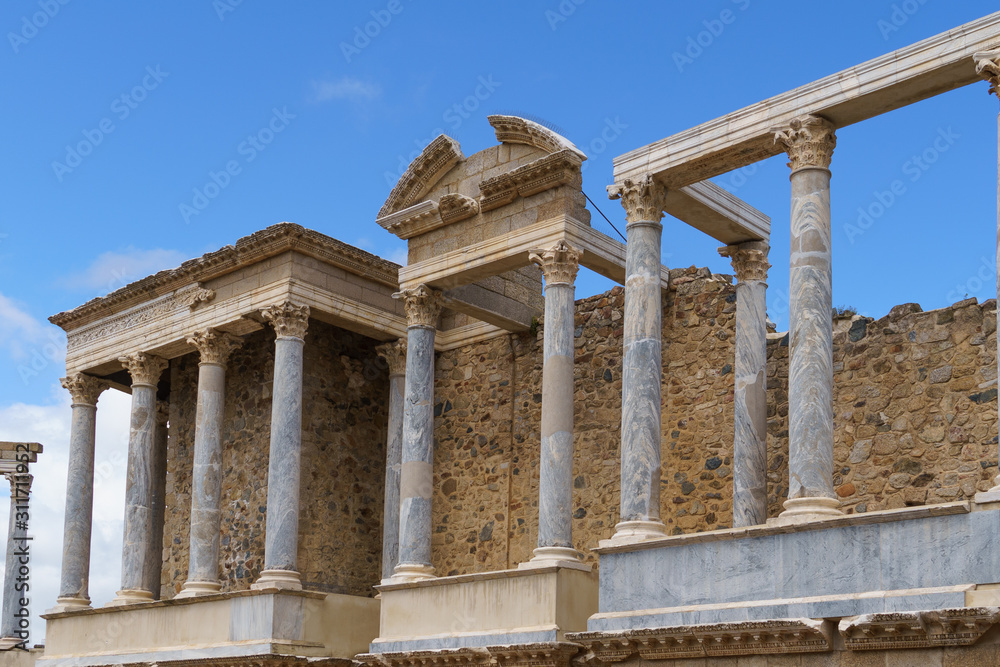 Obraz premium Scaenae frons in the Antique Roman Theatre in Merida. Panorama image. The Archaeological Ensemble of Merida is declared a UNESCO World Heritage Site Ref 664. Orange and teal style