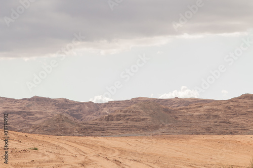 Desert, red mountains, rocks and cloudy sky. Egypt, color canyon.