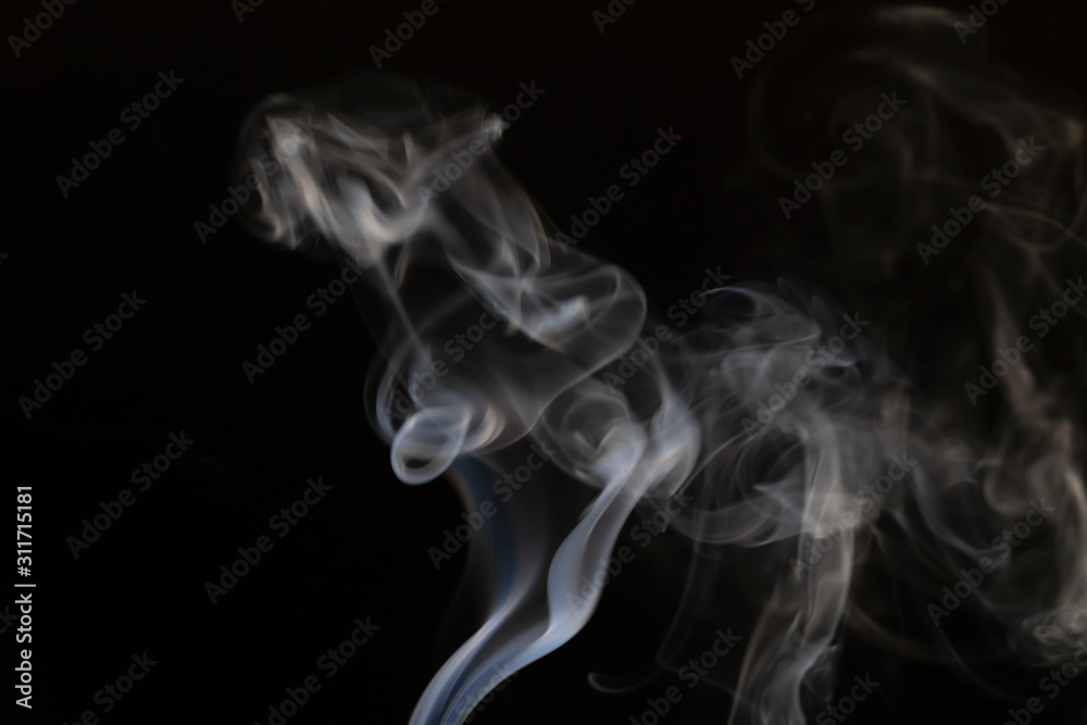 Abstract smoke background with copy space on black background. Blue-white smoke rose from the incense stick. Figures of smoke